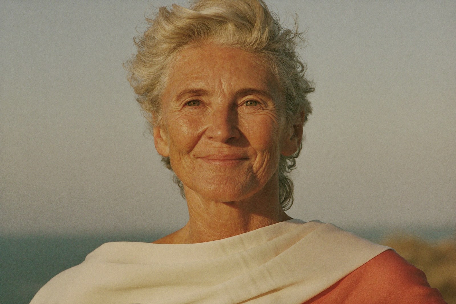 Formation féminité : portrait rayonnant d'une femme de cinquante ans aux cheveux naturels
